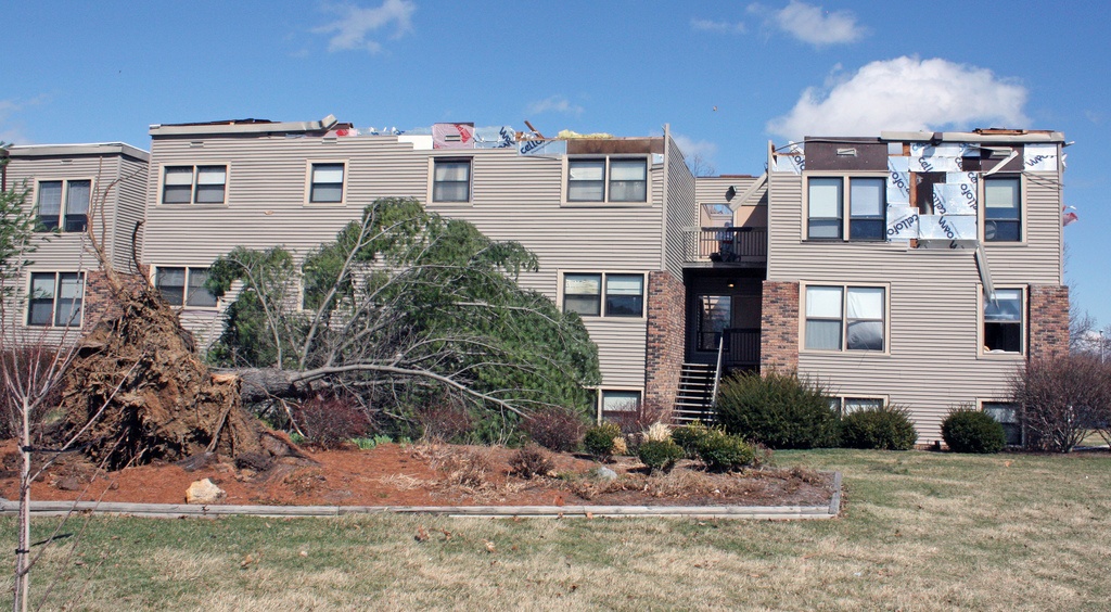 Apartment building with damage to a roof from a fallen tree
